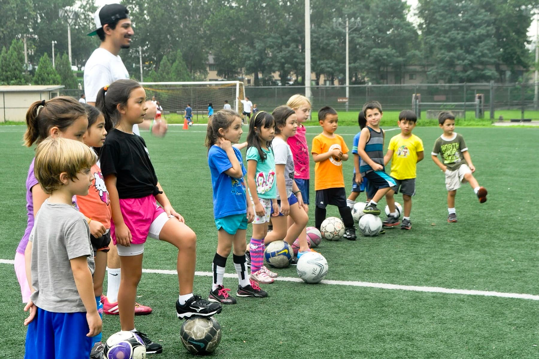 U.S. and Korean children line up for soccer drills at a charity camp on the Seoul American High School field on August 20, 2014 — the kind of practice day that still starts with breakfast and a water bottle.